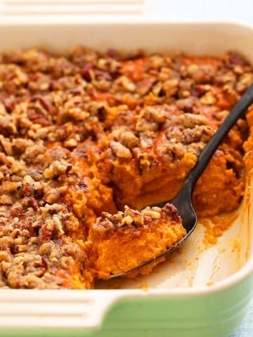 a spoonful of sweet potato souffle in a ceramic square dish.