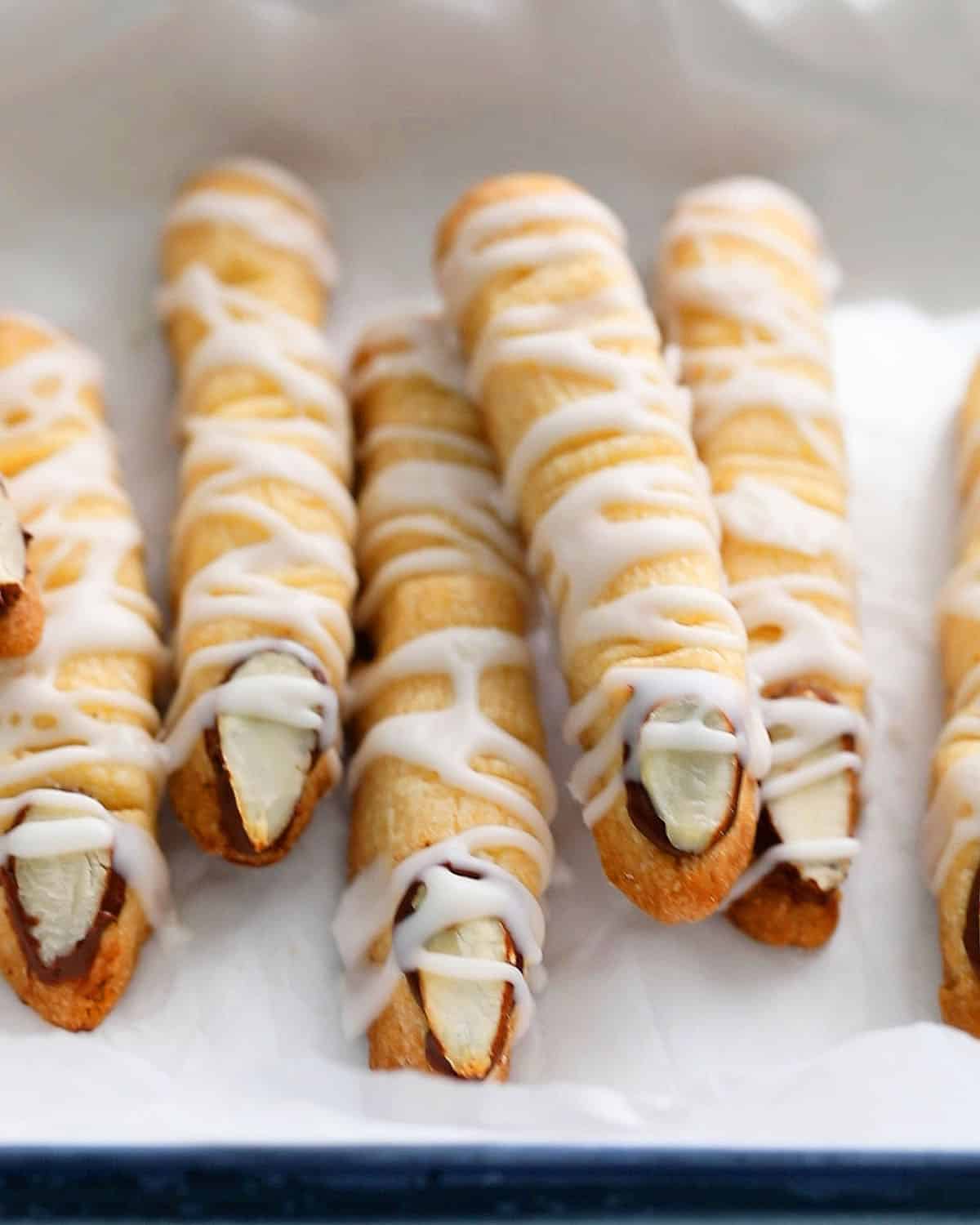 7 white finger cookies in a white tray.