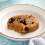 one piece of brown chocolate chip cookie dough in a white plate.