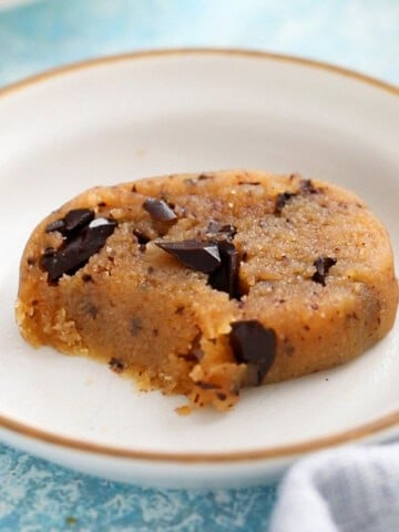 one piece of brown chocolate chip cookie dough in a white plate.