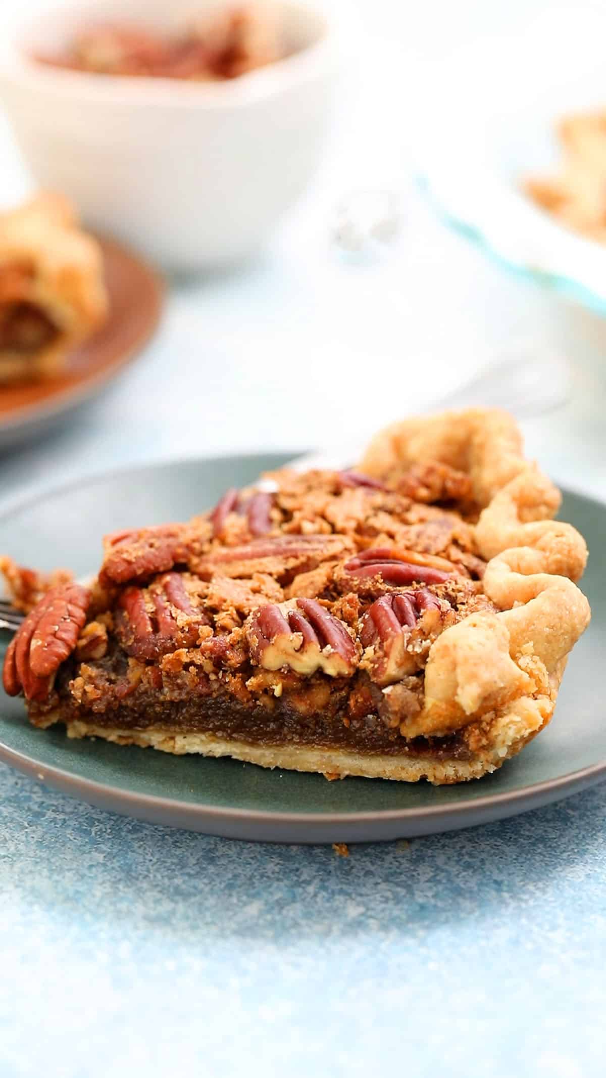 a slice of pecan pie placed on a small green plate.