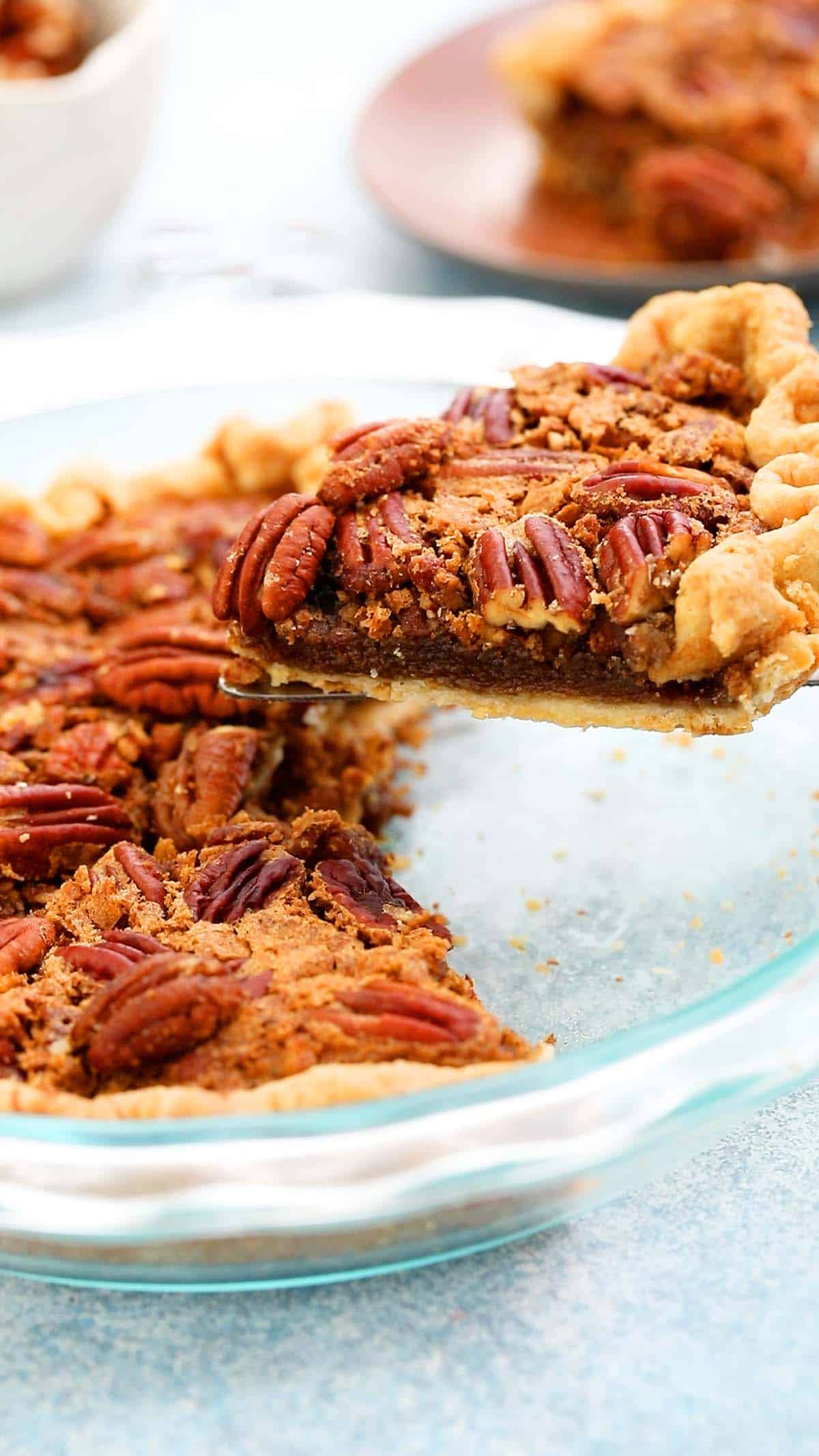 a slice of pecan pie being lifted from a pie plate.