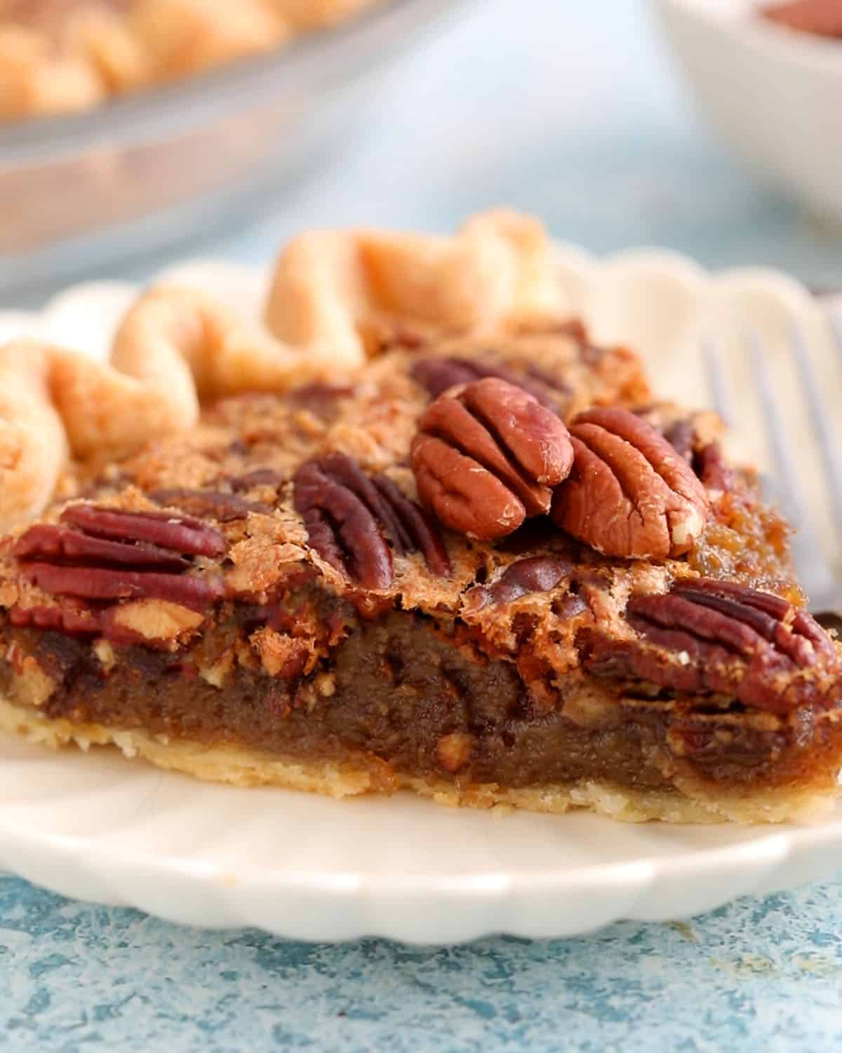 one slice of pecan pie on a white plate.