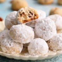 white pecan snowball cookies arranged om a white plate.