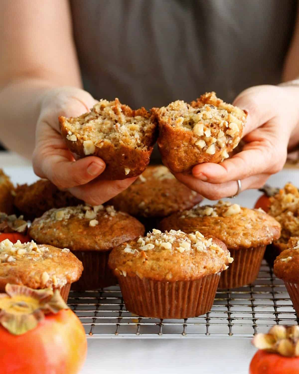 a lady holding one persimmon muffin.