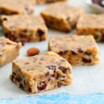 squares of brown almond bars placed on a white parchment paper.