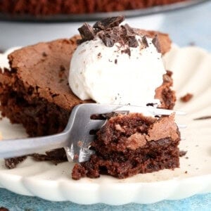 one slice of almond flour chocolate cake with white cream in a white plate.