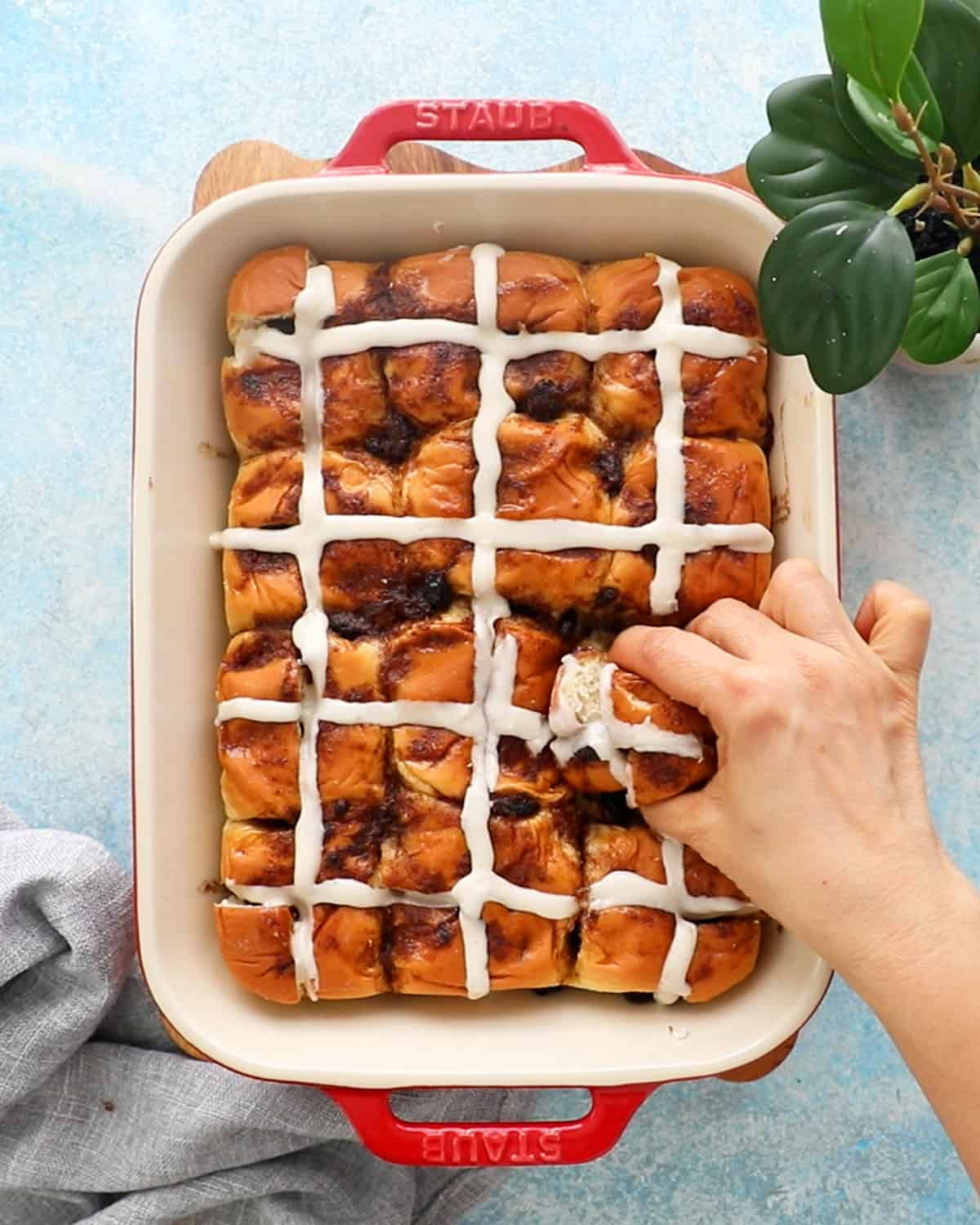 hot cross buns in a red baking pan.