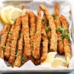breaded asparagus in a white tray.