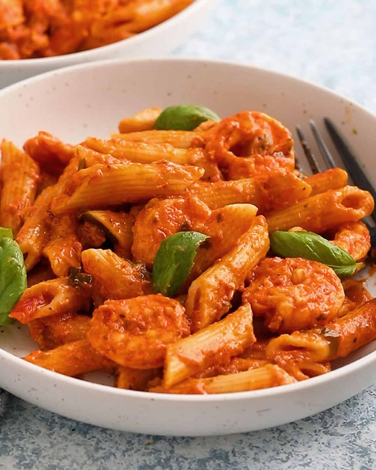 pink shrimp pasta in a white bowl.