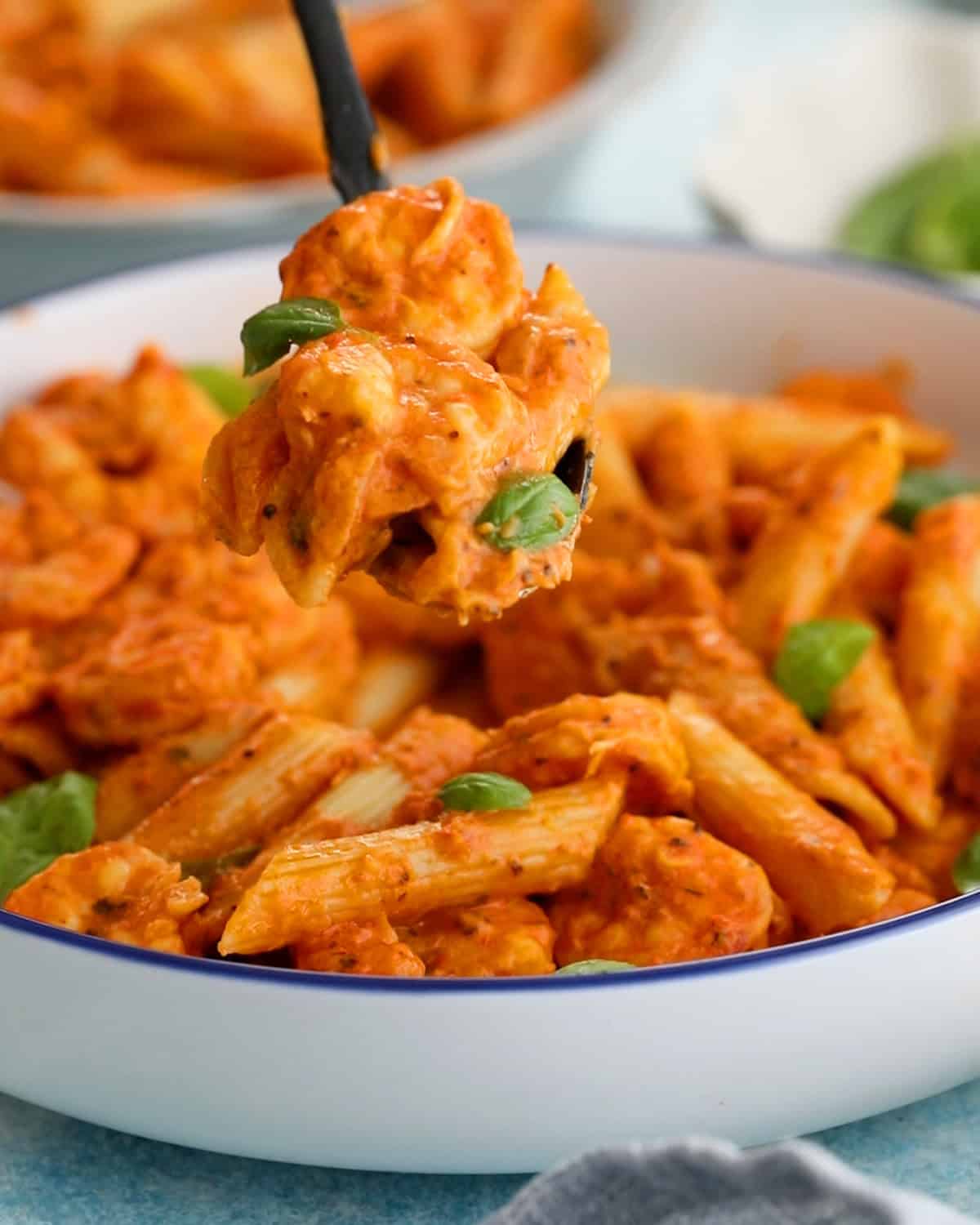pink shrimp pasta in a white bowl.
