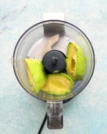 three avocado halves in a small food processor.