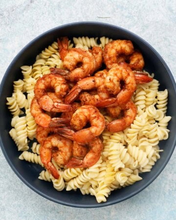 cooked pasta and shrimp in a large blue bowl.