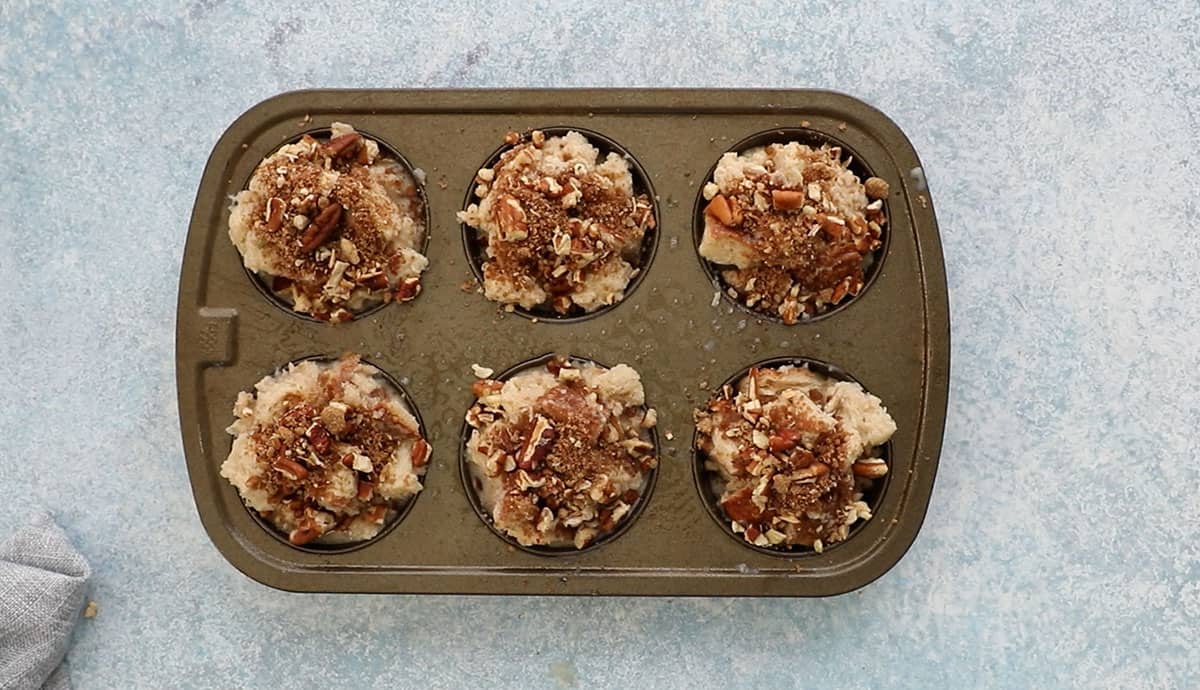 one 6 cup metal muffin pan with with french toast mixture ready to be baked. 