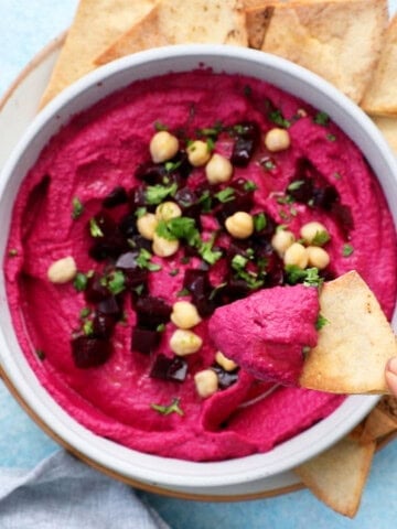 pink beet hummus in a white bowl.