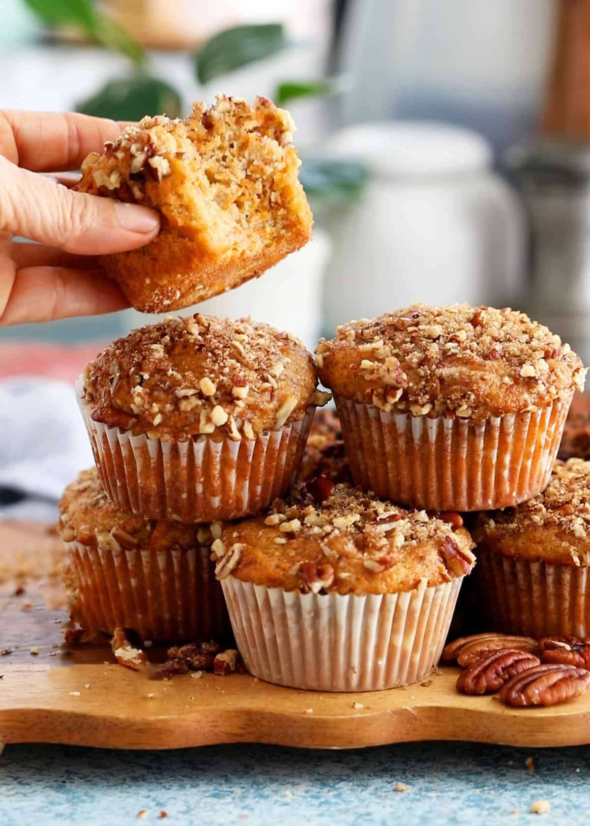 6 orange sweet potato muffins on a brown board.