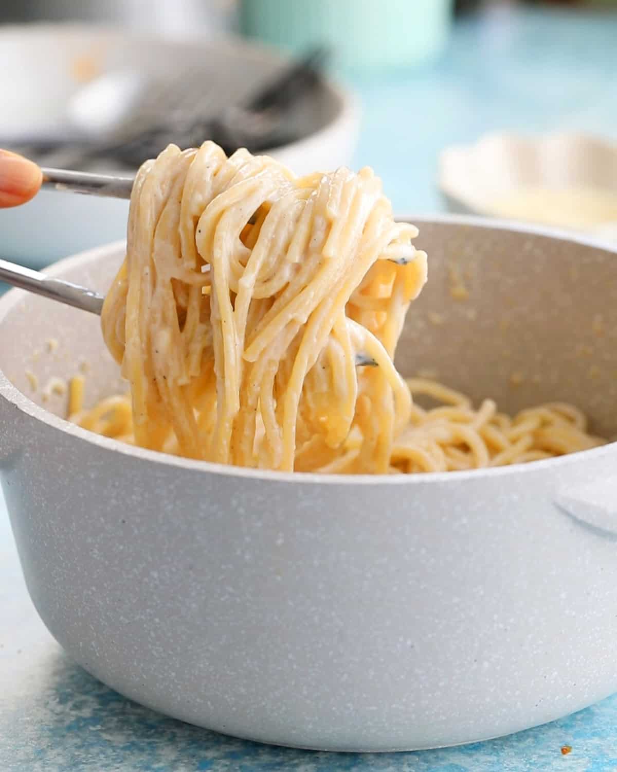 white alfredo pasta in a white pot.
