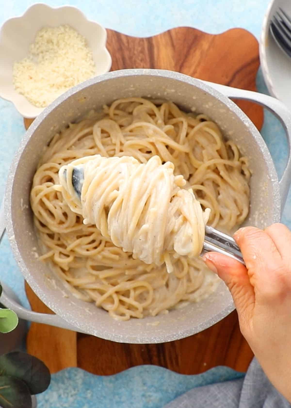white alfredo pasta in a white pot.