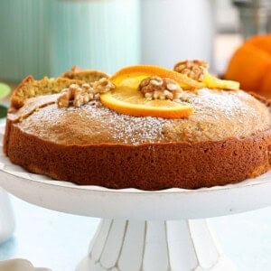 one orange cake in a white cake stand.