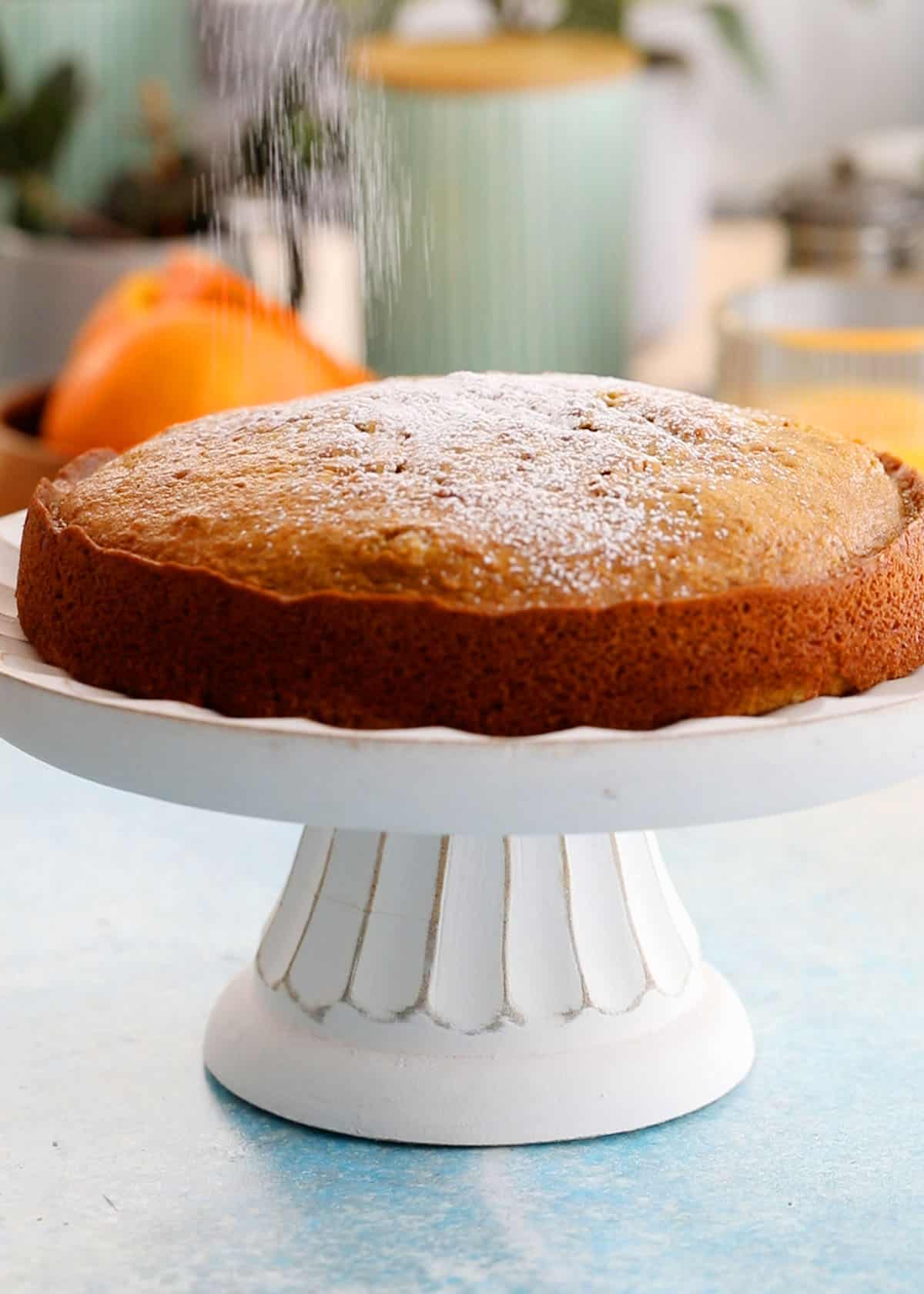 one orange cake in a white cake stand.