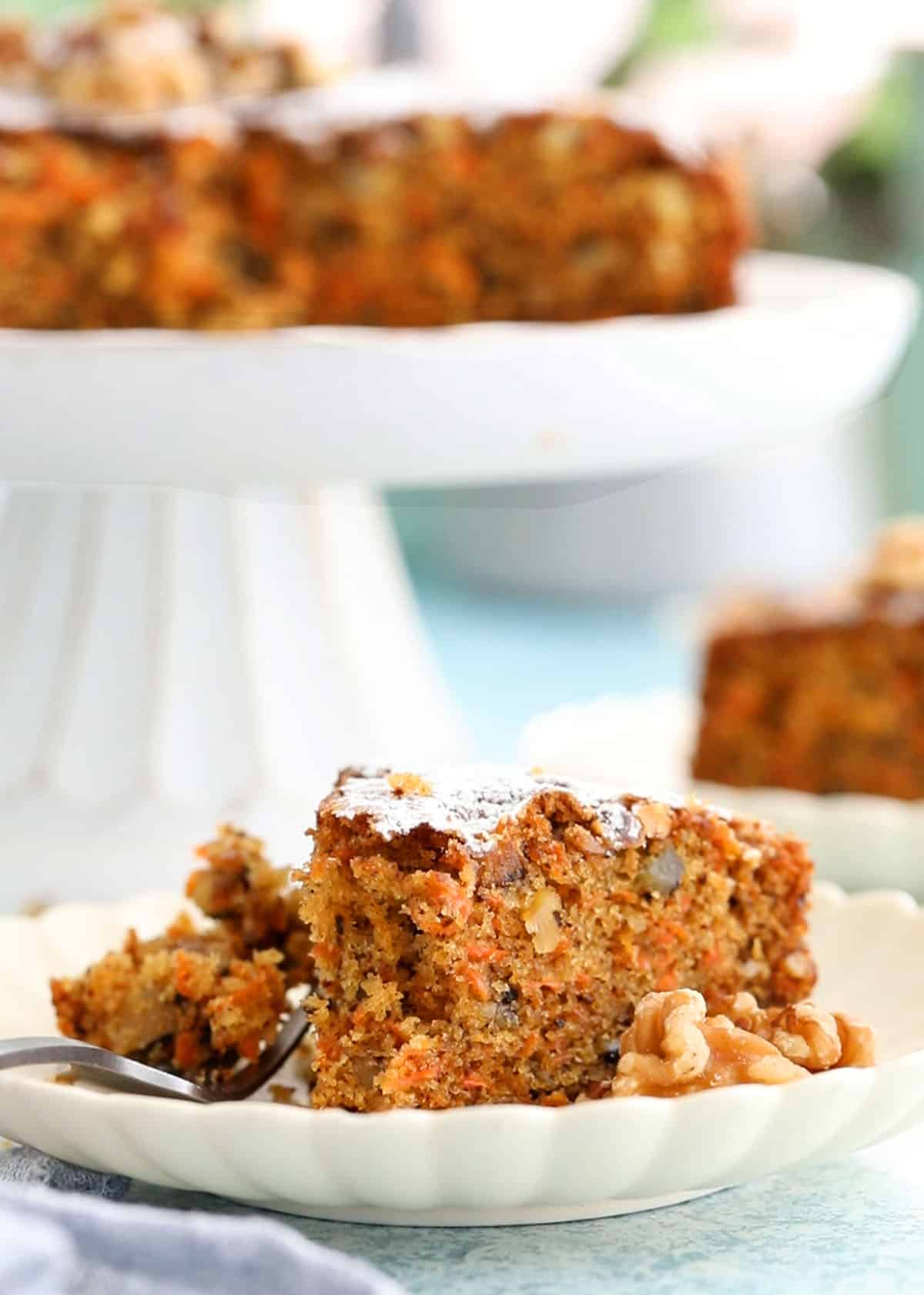 one slice of carrot walnut cake in a white plate.