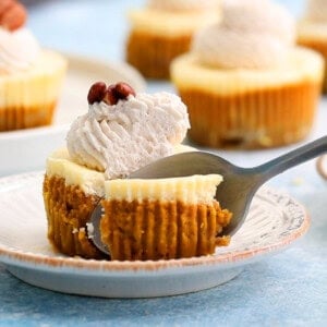 A metal spoon cutting into a brown and white layered cheesecake.