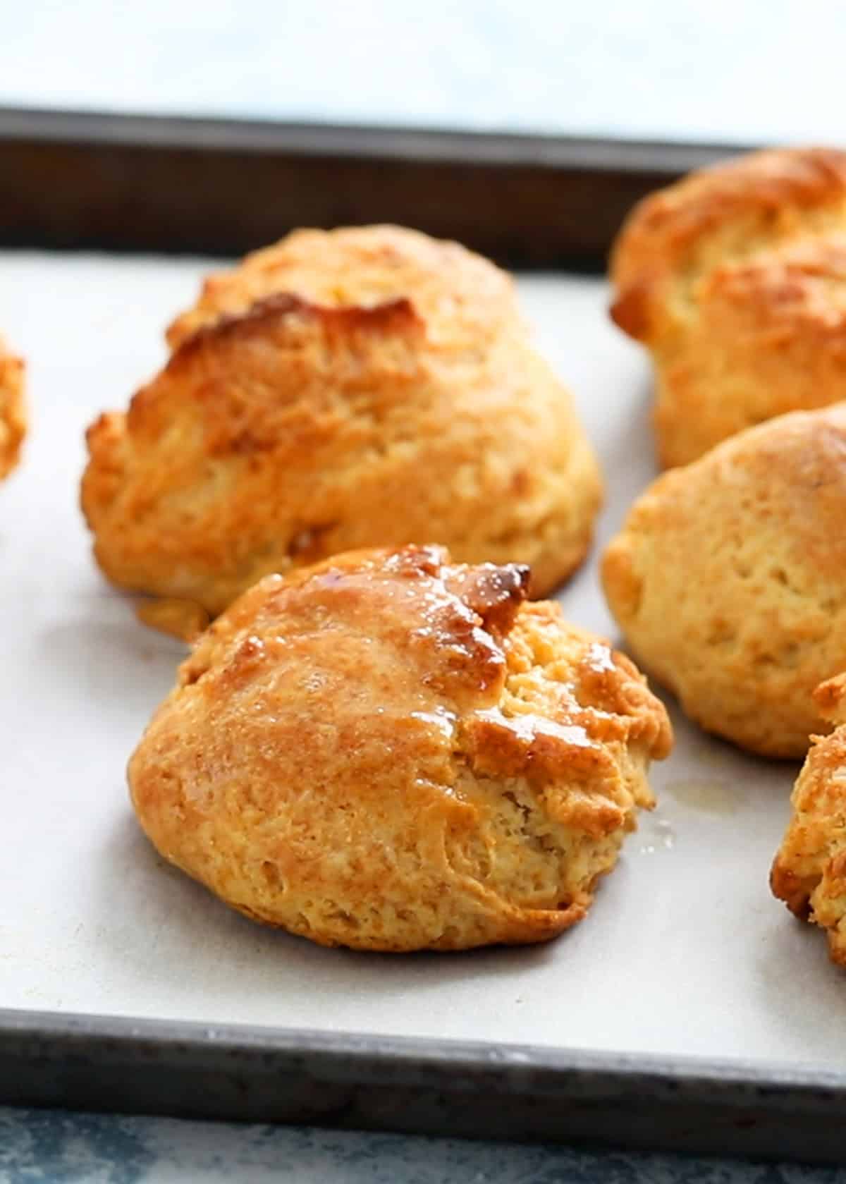 baked drop biscuits in a parchment lined baking sheet.
