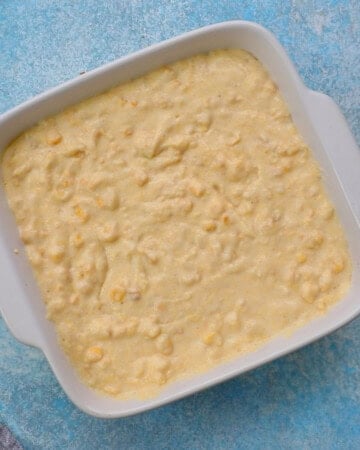 corn casserole batter in a square white square baking dish.
