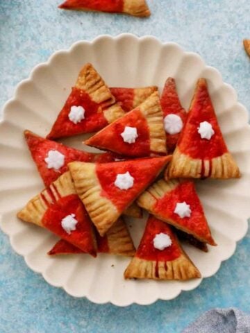 red triangle cookies placed on a white plate.