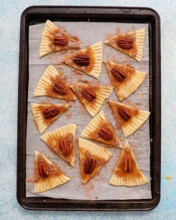 unbaked pie crust cookie triangles in a baking sheet.
