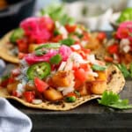 3 yellow potato tacos on a balck board.