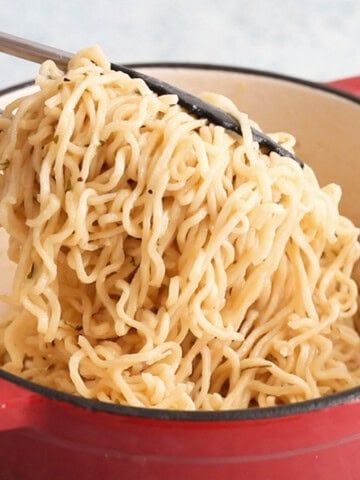 white garlic ramen noodles in a red pot.