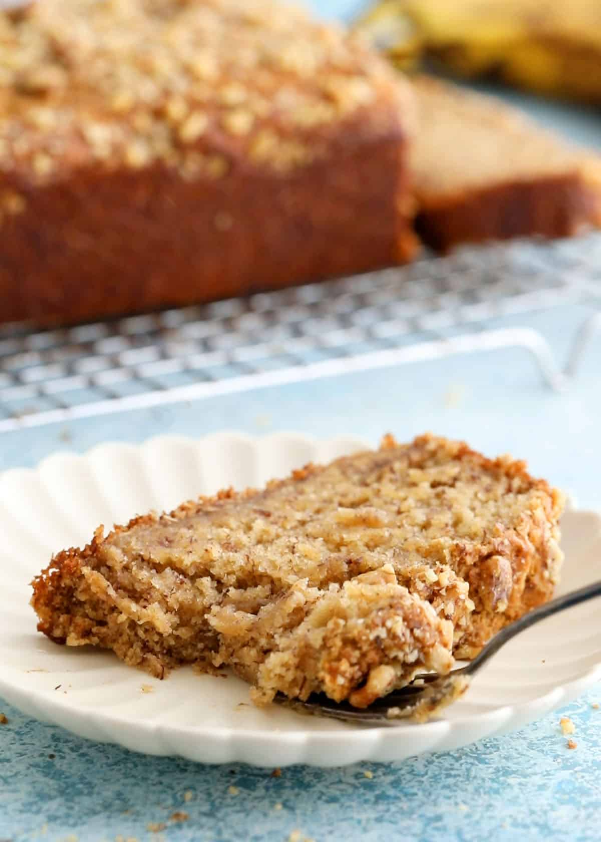 one slice of eggless banana bread in a white plate.