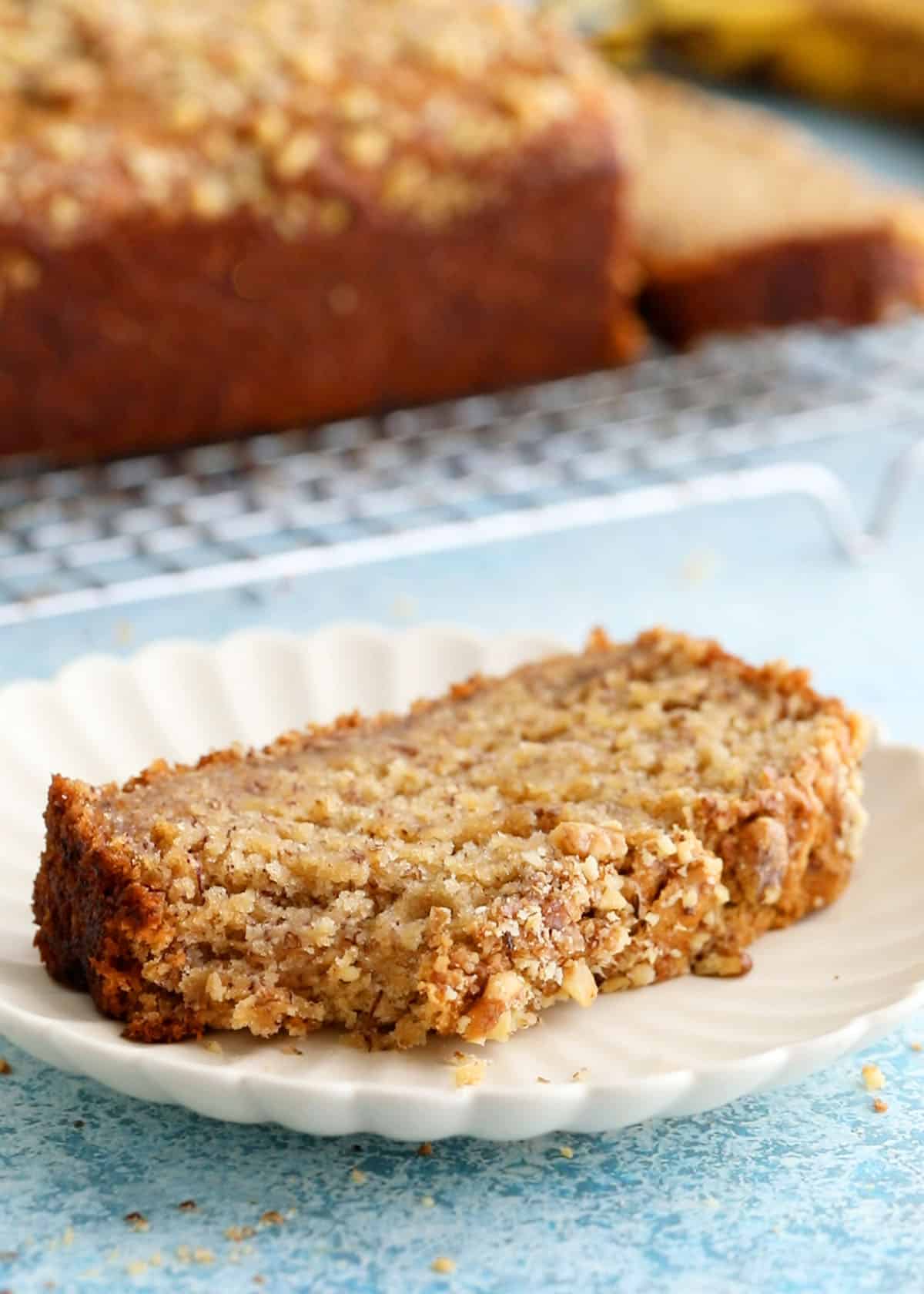 one slice of eggless banana bread in a white plate.