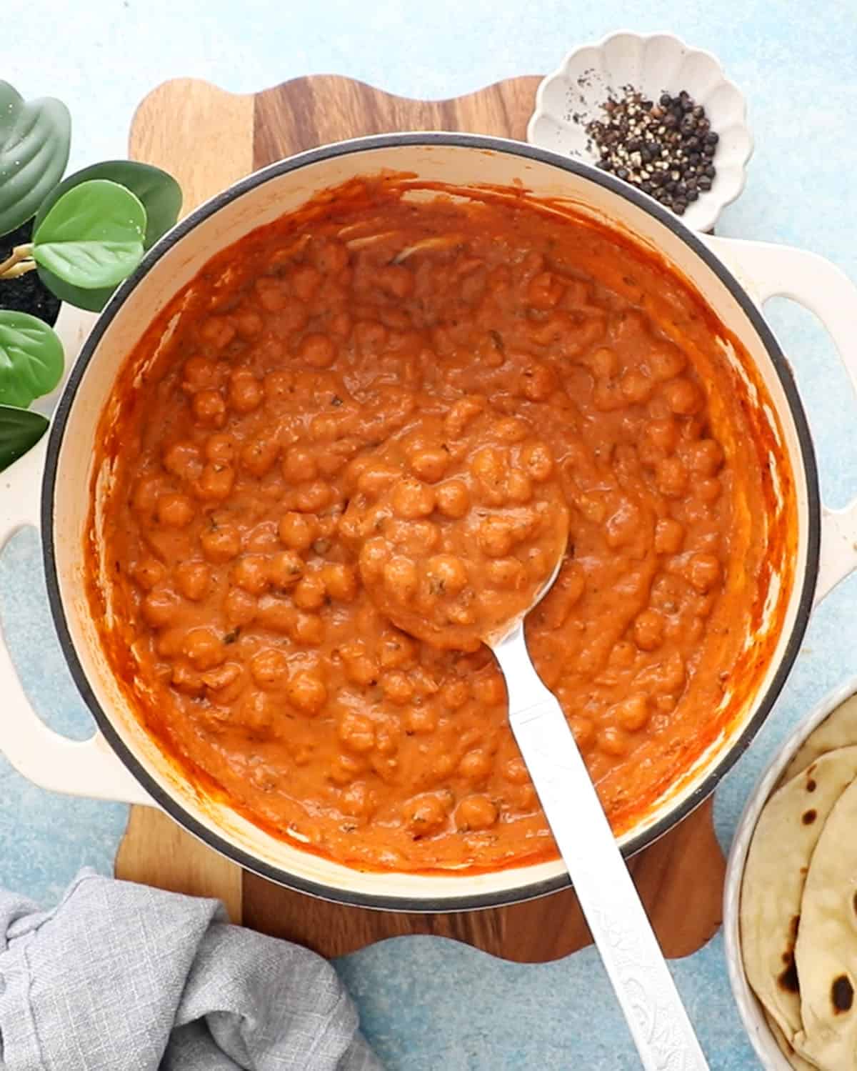 Orange butter chickpeas in a white pan.