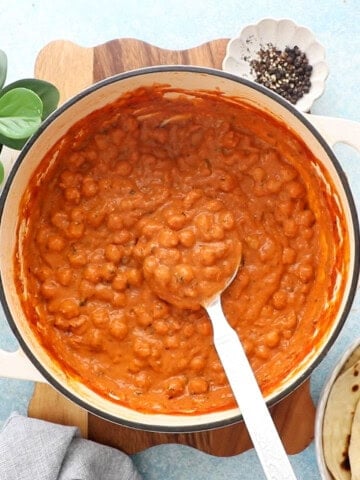 Orange colored Indian Butter Chickpeas in a white pan.