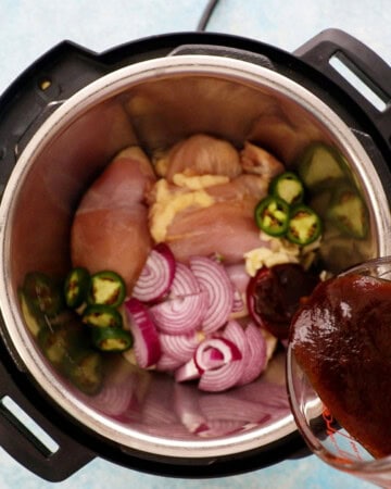 pink chicken, onions, green jalapeno in an instant pot.