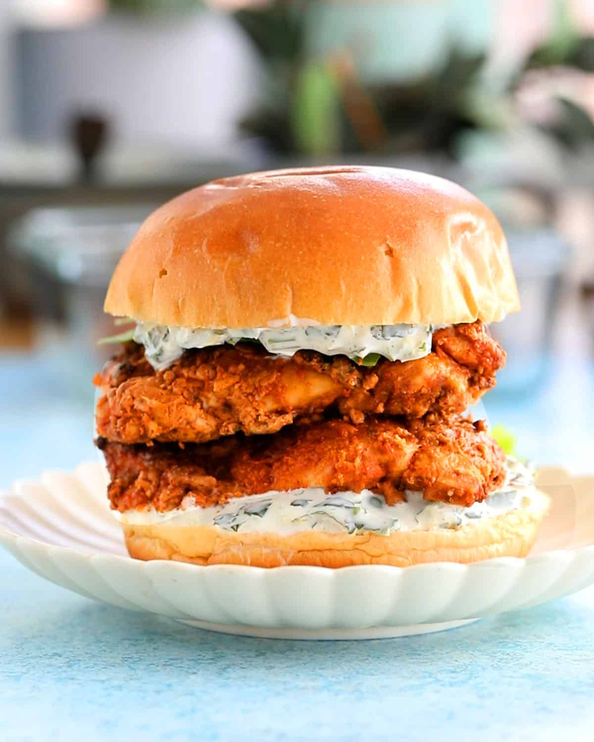 one tandoori chicken sandwich on a white plate.