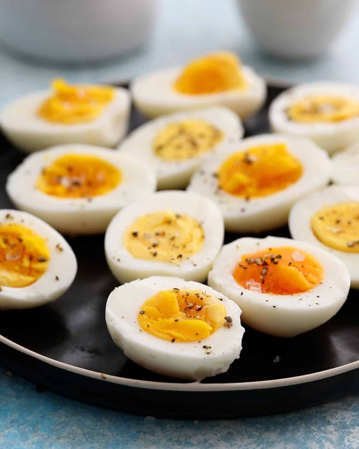 11 boiled egg halves placed in a black plate.