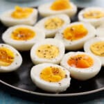 11 boiled egg halves placed in a black plate.