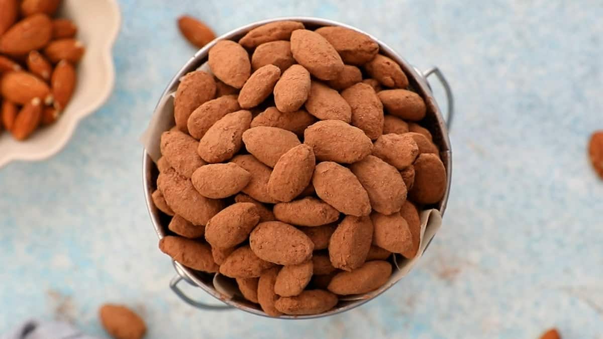 brown cocoa almonds in a metal cup.