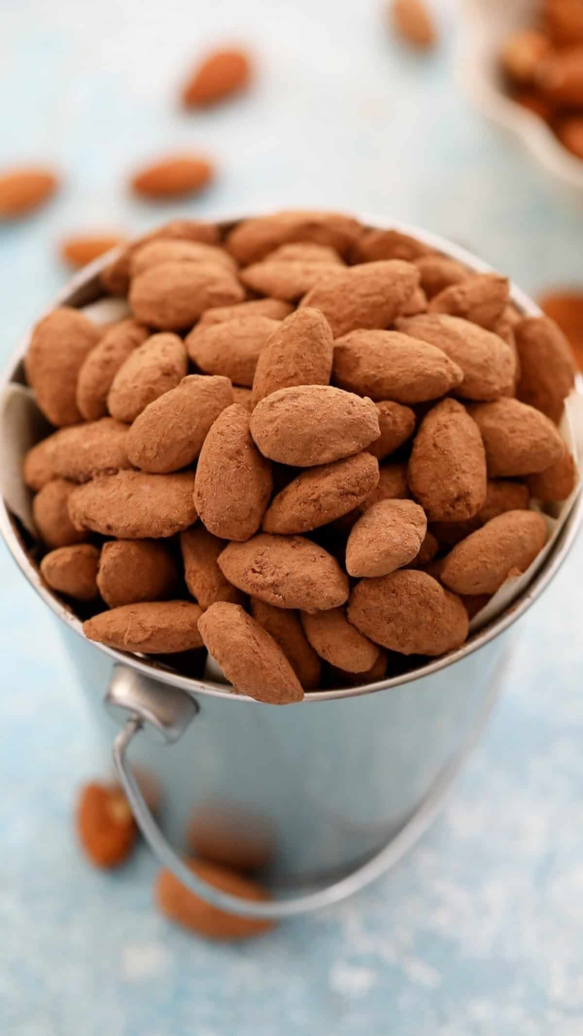 brown cocoa almonds in a metal cup.
