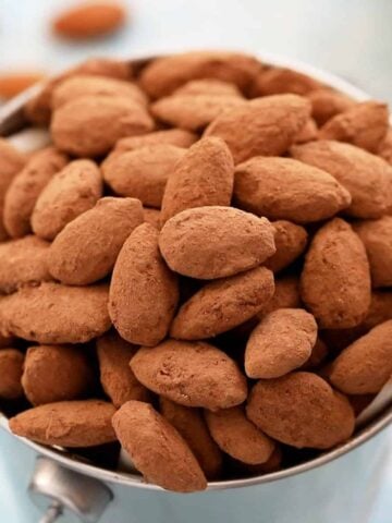 brown cocoa almonds in a metal cup.
