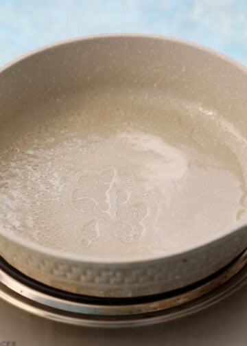 white skillet placed on a stove top.
