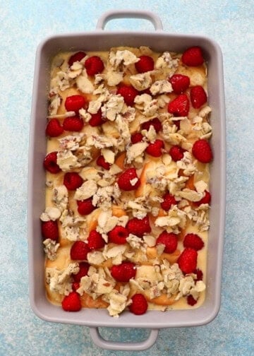 assembled raspberry french toast casserole in a grey dish.