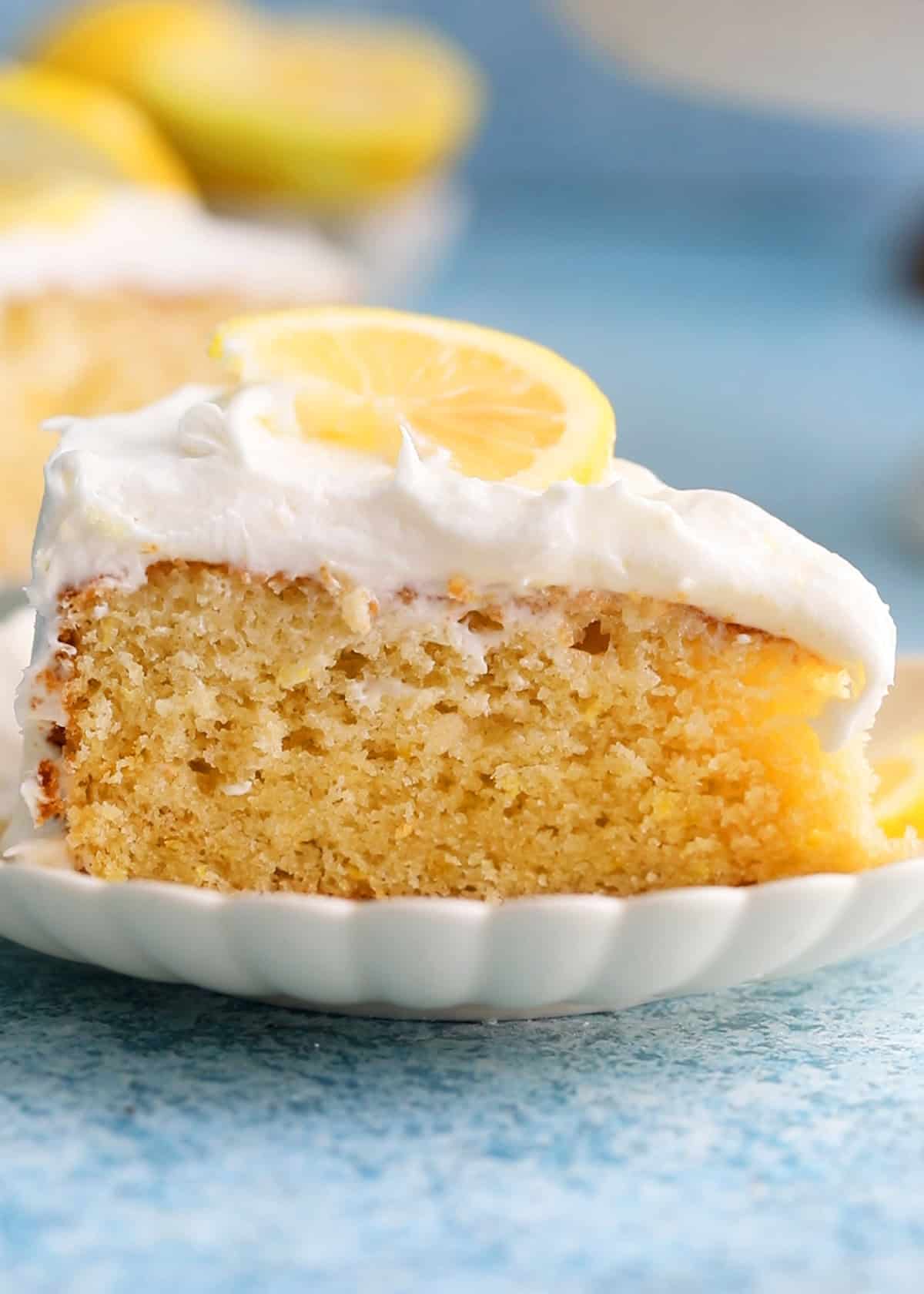 one slice of lemon cake in a white fluted plate.