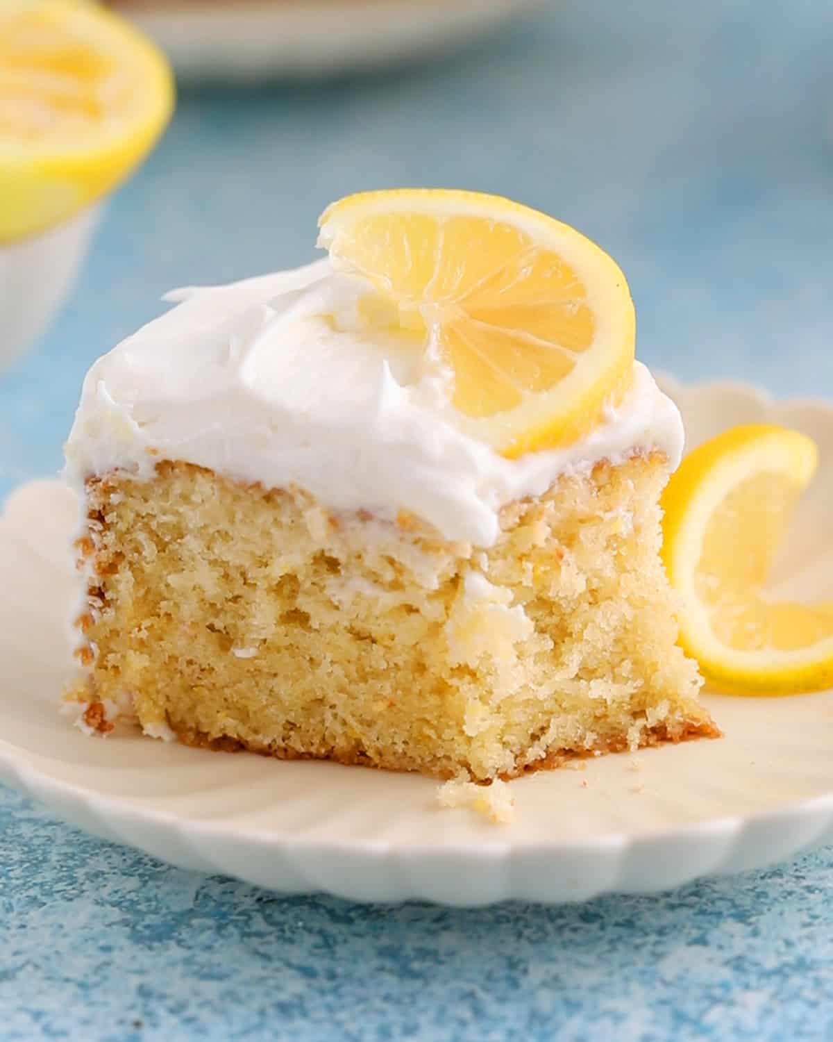 one slice of lemon cake in a white fluted plate.