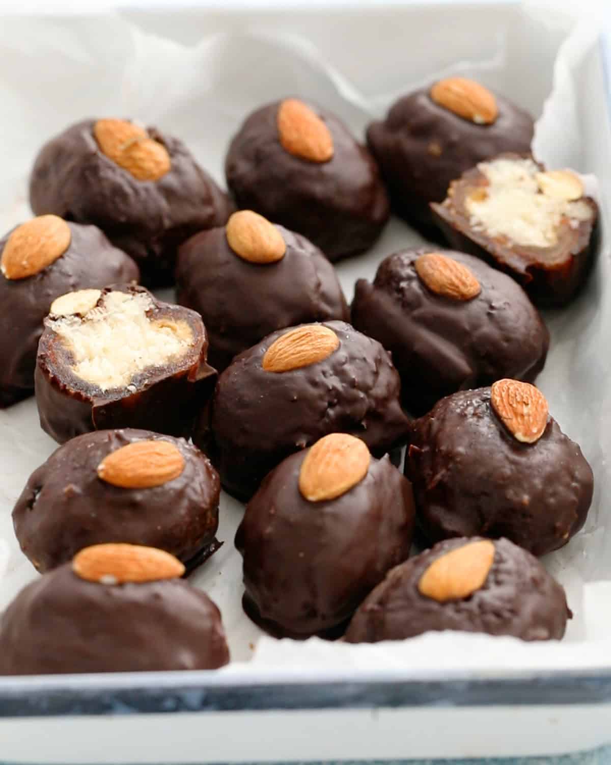 12 chocolate covered almond joy dates in a white tray.