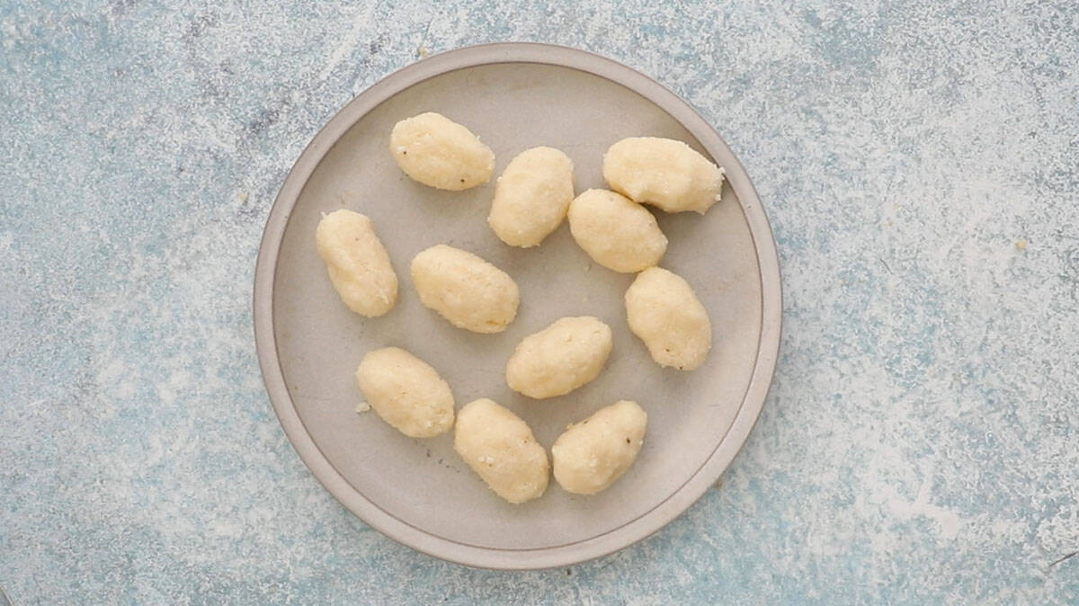 11 white coconut ovals placed in a grey plate.