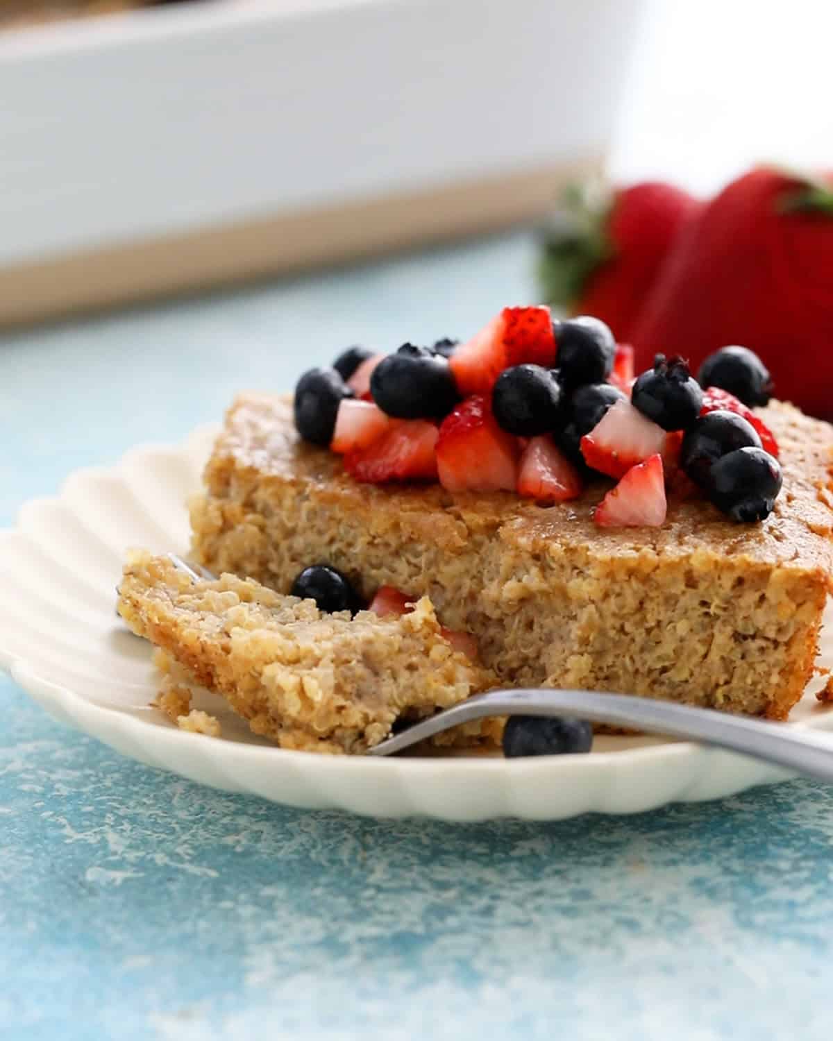 one slice of quinoa breakfast bake in a white plate along with a fork.